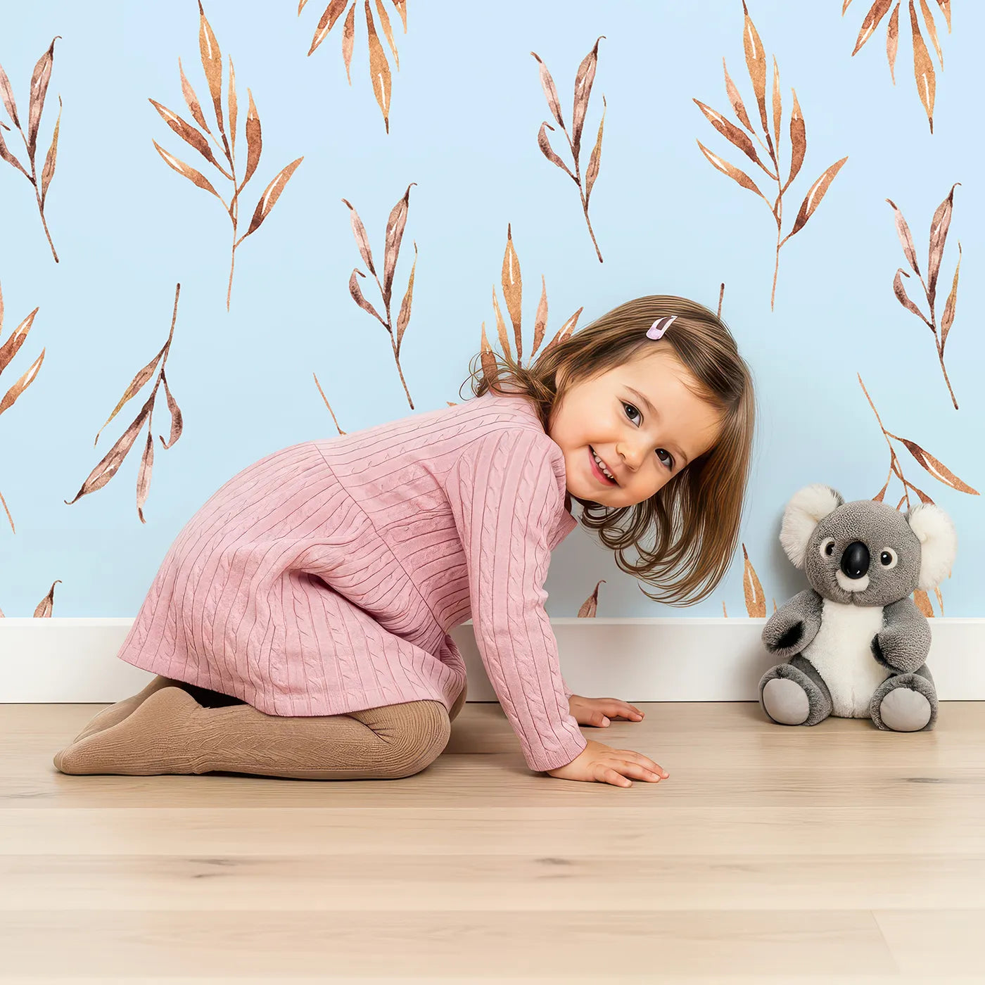 Lovely child standing in front of Whimsy Tots Rustle and Grace Wallpaper in Sky with branch, leaf, stem, botanical in design.