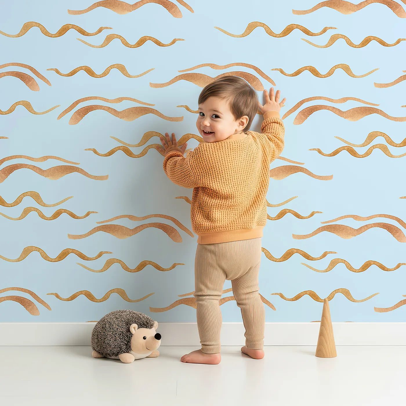 Lovely child standing in front of Whimsy Tots Soft Wave Rhythm Wallpaper in Sky Blue with wave, curve, line, brushstroke, abstract in design.