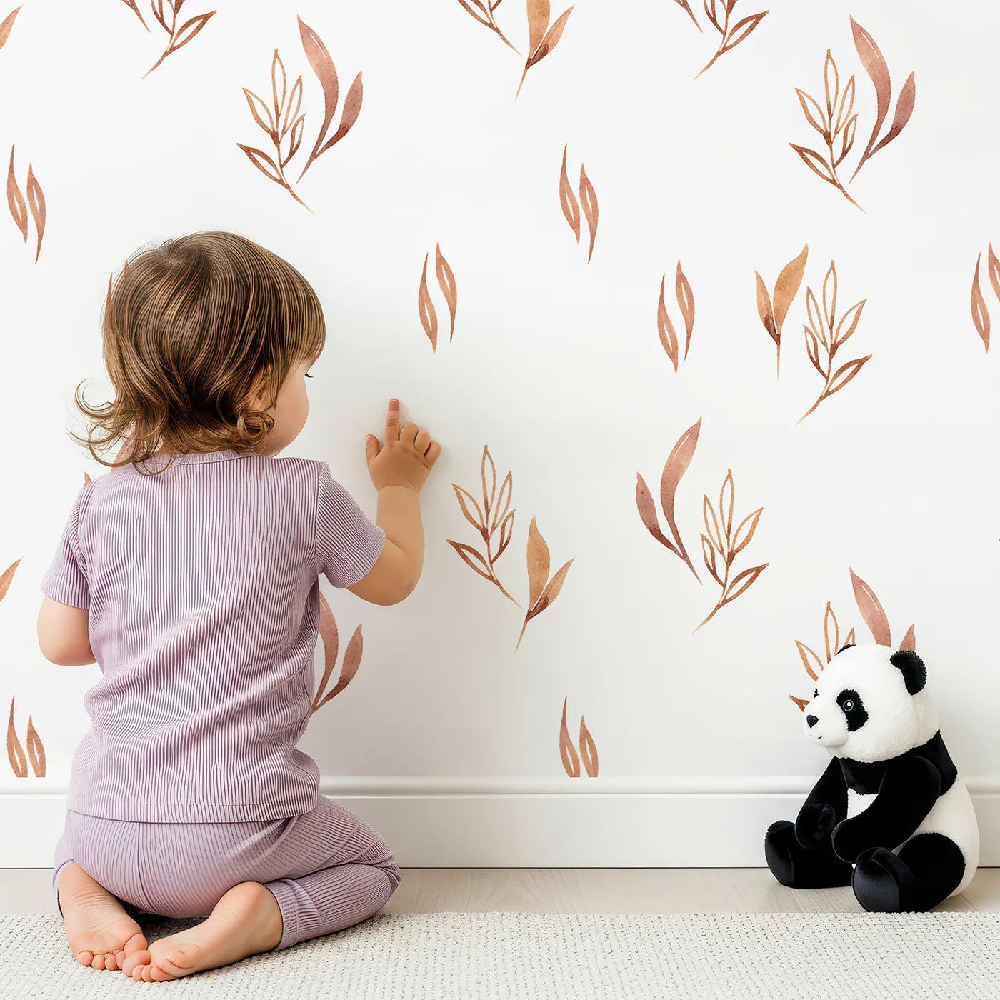 Lovely child standing in front of Whimsy Tots Rustling Meadow Sprigs Wallpaper in White with leaf, sprig, botanical, plant in design.