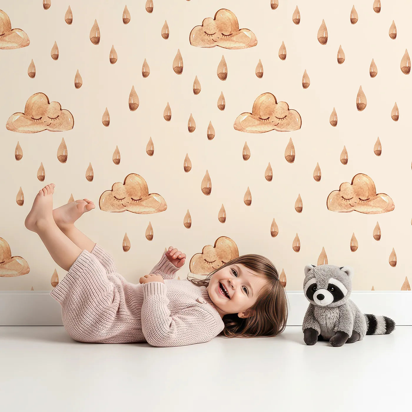 Lovely child standing in front of Whimsy Tots Rainy Day Nap Wallpaper in Cream with cloud, raindrop, sleepy face in design.
