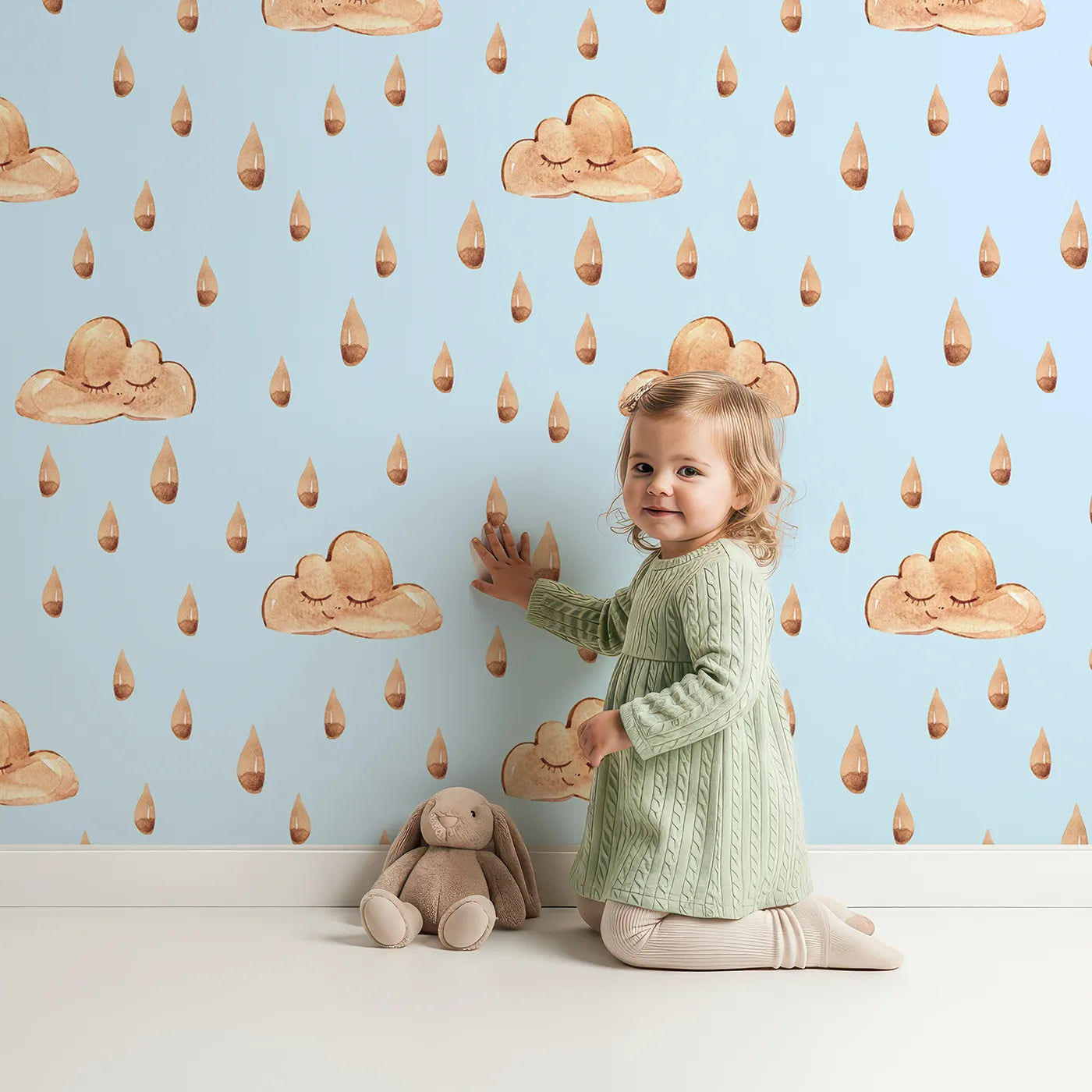 Lovely child standing in front of Whimsy Tots Rainy Day Nap Wallpaper in Blue with cloud, raindrop, sleepy face in design.