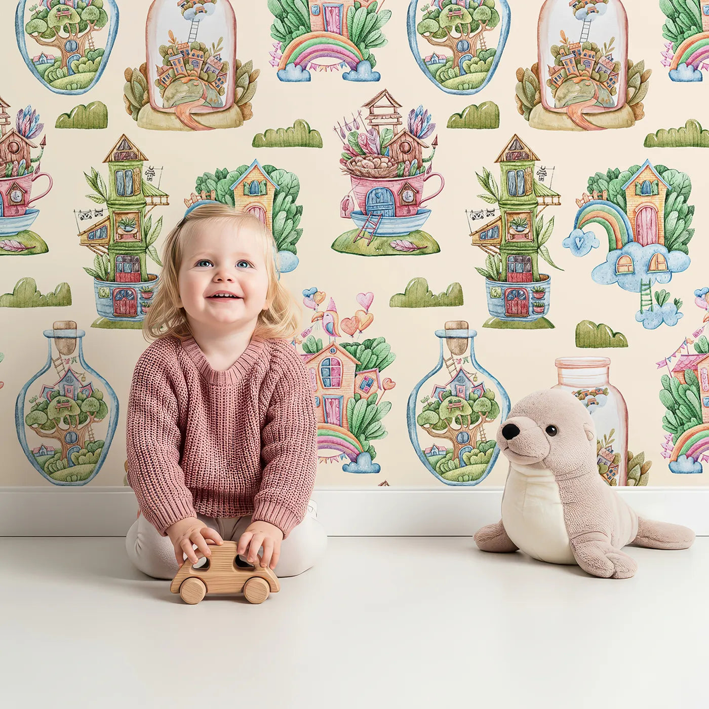 Lovely child standing in front of Whimsy Tots Whimsy Village Dreams Wallpaper in Beige with house, rainbow, cup, jar, cloud, balloon in design.