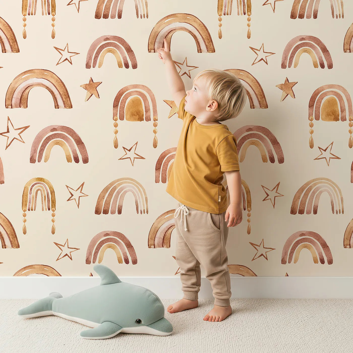 Lovely child standing in front of Whimsy Tots Golden Boho Rainbows Wallpaper in Beige with rainbow, star in design.