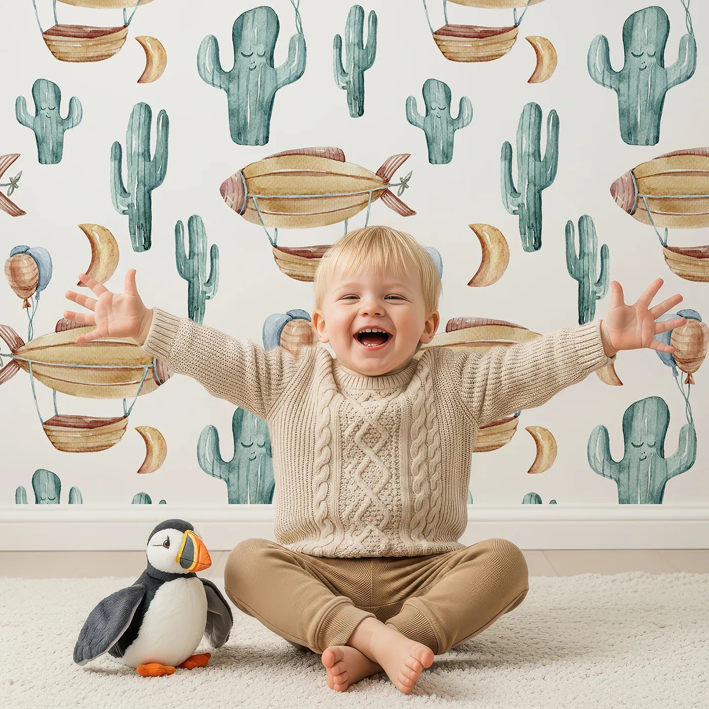 Lovely child standing in front of Whimsy Tots Cactus Cloud Voyage Wallpaper in White with cactus, airship, balloon, moon in design.