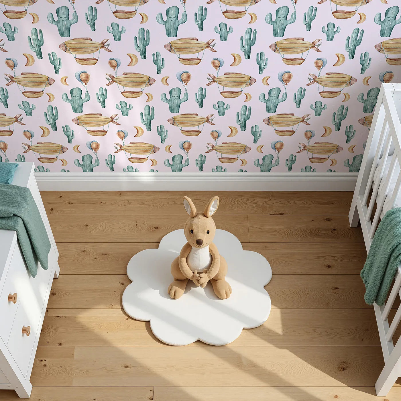 Top-Down view of Whimsy Tots' Cactus Cloud Voyage Wallpaper in Blush Pink (W3391B).Blushing skies and dreamy airships meet friendly cacti in a gentle desert journey.