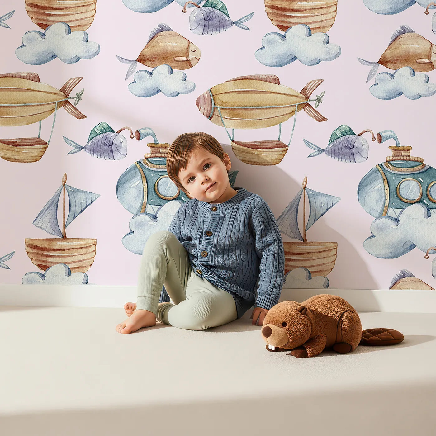 Lovely child standing in front of Whimsy Tots Skybound Explorers Wallpaper in Blush Pink with submarine, boat, fish, cloud, airship in design.