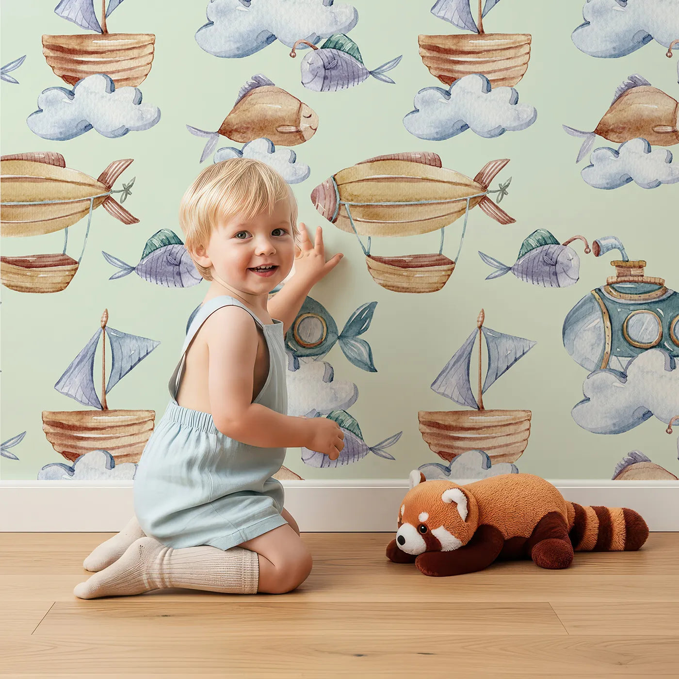 Lovely child standing in front of Whimsy Tots Skybound Explorers Wallpaper in Mint Green with submarine, boat, fish, cloud, airship in design.