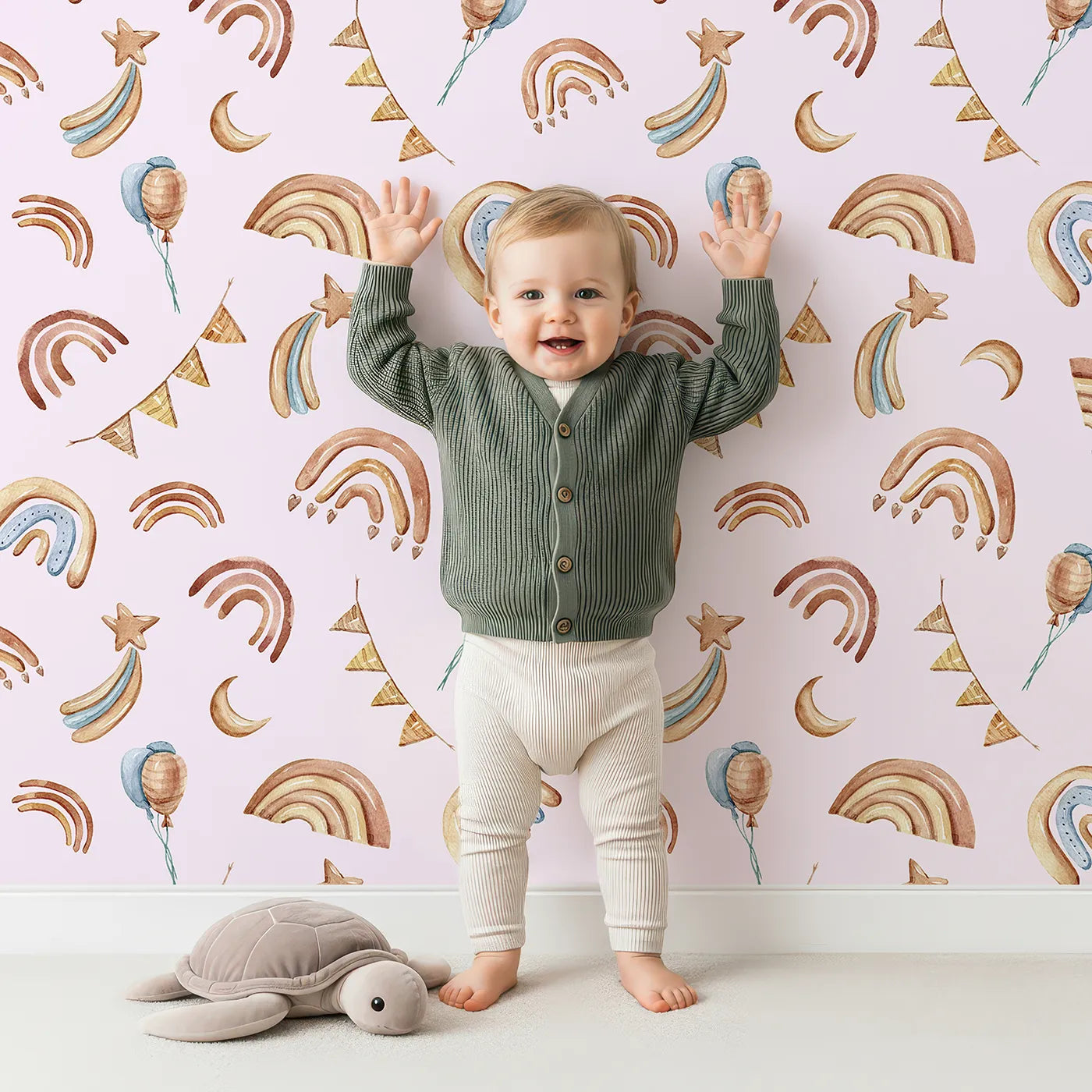 Lovely child standing in front of Whimsy Tots Sky Bloom Party Wallpaper in Pink with rainbow, balloon, moon, star, bunting, heart in design.