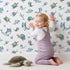 Lovely child standing in front of Whimsy Tots Dreamy Sea Pals Wallpaper in White with whale, turtle, fish, star, coral in design. Lovely child standing in front of Whimsy Tots Dreamy Sea Pals Wallpaper in White with whale, turtle, fish, star, coral in design.