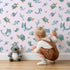 Lovely child standing in front of Whimsy Tots Dreamy Sea Pals Wallpaper in Blush Pink with whale, turtle, fish, star, coral in design. Lovely child standing in front of Whimsy Tots Dreamy Sea Pals Wallpaper in Blush Pink with whale, turtle, fish, star, coral in design.