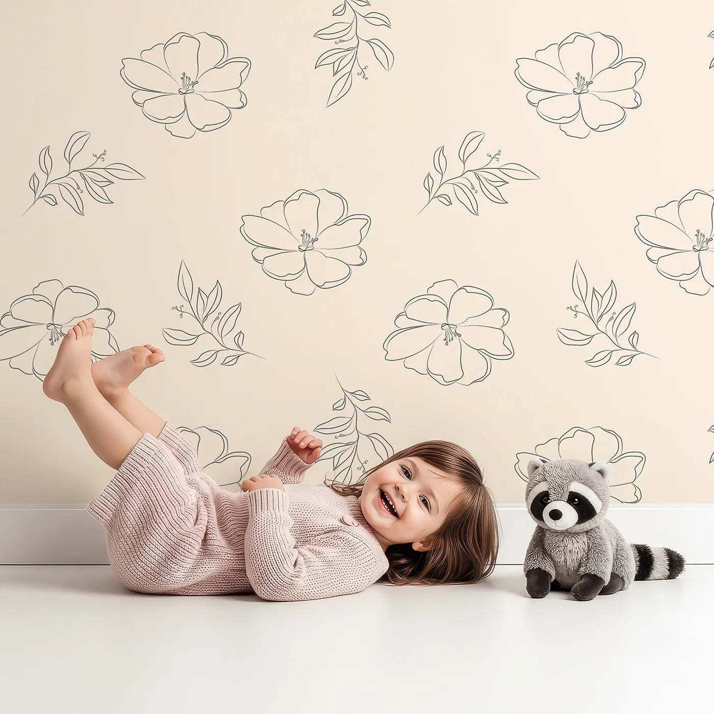 Lovely child standing in front of Whimsy Tots Petal Bloom Grace Wallpaper in Sand with flower, leaf, blossom, sprig in design.