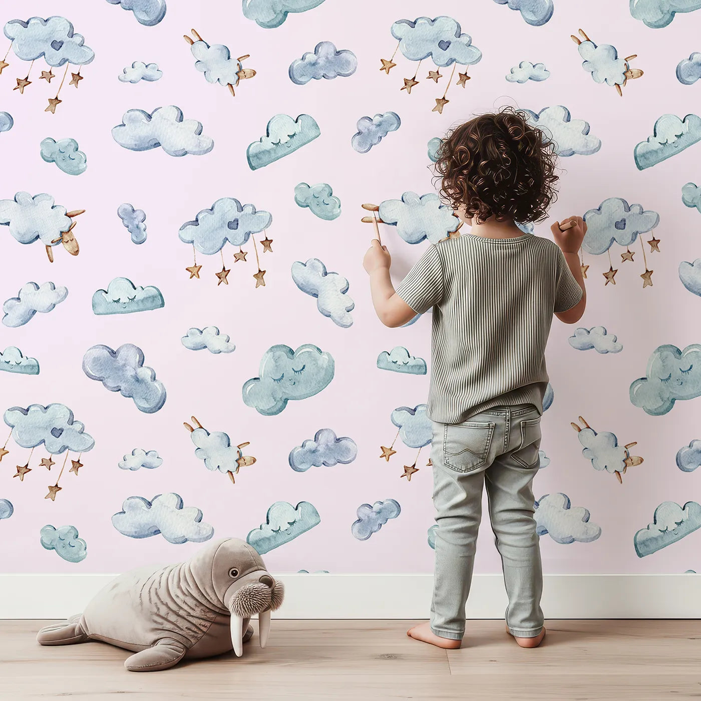 Lovely child standing in front of Whimsy Tots Cloudy Dreams Parade Wallpaper in Blush Pink with cloud, star, sheep, sky in design.