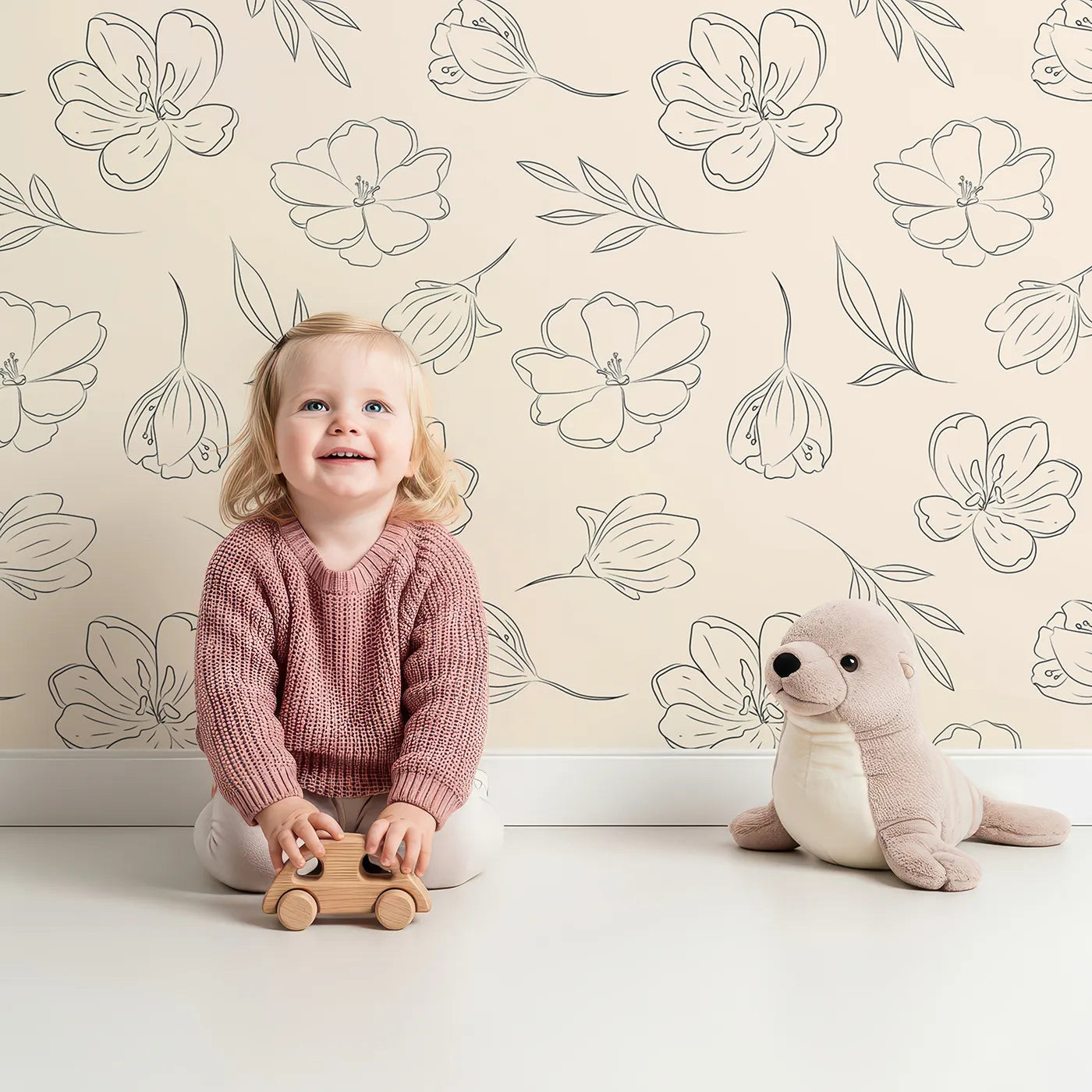 Lovely child standing in front of Whimsy Tots Petal Outline Bloom Wallpaper in Sand with flower, petal, bell flower, sprig, leaf, botanical in design.