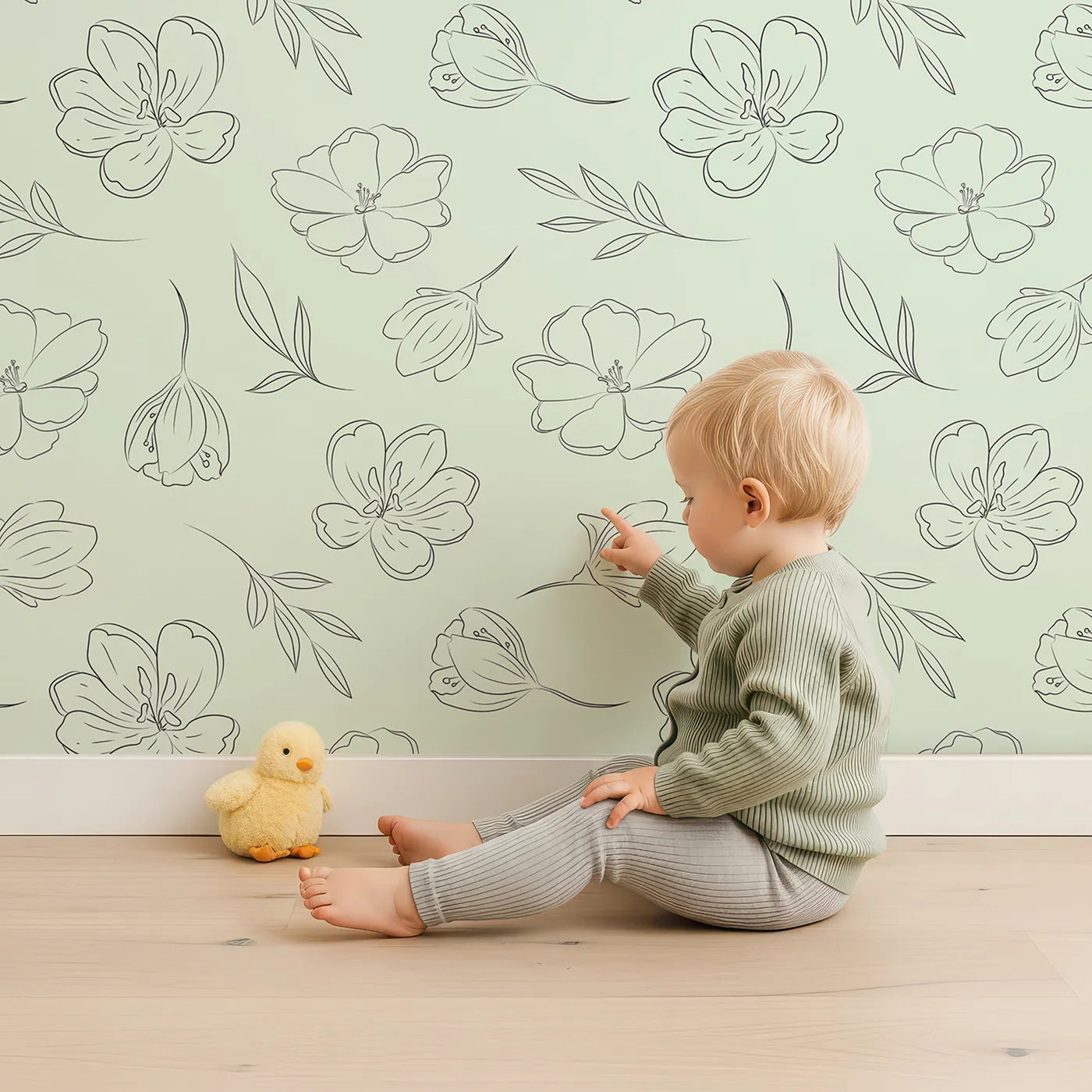 Lovely child standing in front of Whimsy Tots Petal Outline Bloom Wallpaper in Green with flower, petal, bell flower, sprig, leaf, botanical in design.