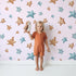 Lovely child standing in front of Whimsy Tots Starlight Scribbles Wallpaper in Blush Pink with star, scribble, doodle in design. Lovely child standing in front of Whimsy Tots Starlight Scribbles Wallpaper in Blush Pink with star, scribble, doodle in design.