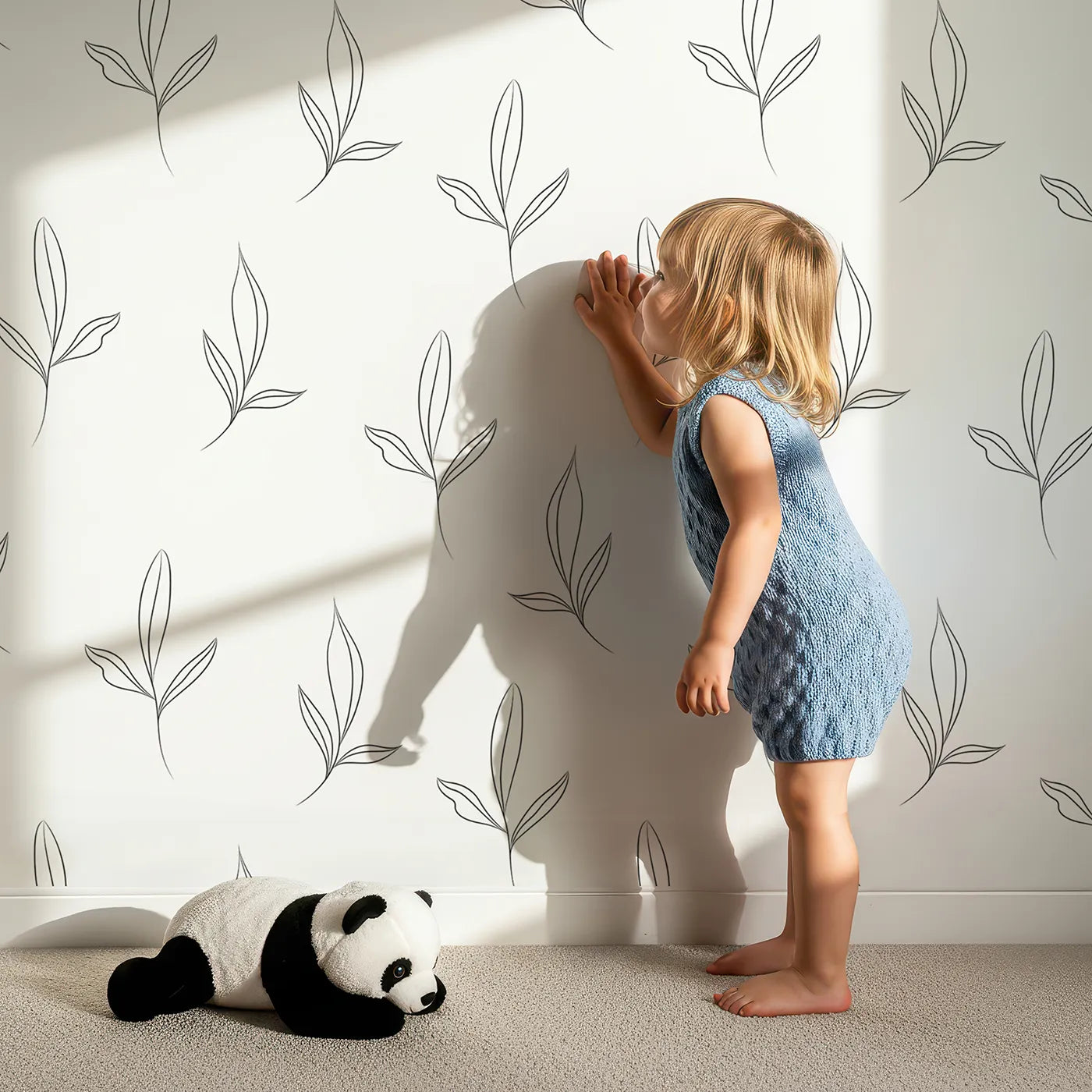Lovely child standing in front of Whimsy Tots Whispering Leaflines Wallpaper in White with leaf, sprig, botanical, line art in design.