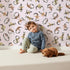 Lovely child standing in front of Whimsy Tots Botanical Numbers Wallpaper in Blush Pink with number, leaf, vine, foliage in design. Lovely child standing in front of Whimsy Tots Botanical Numbers Wallpaper in Blush Pink with number, leaf, vine, foliage in design.
