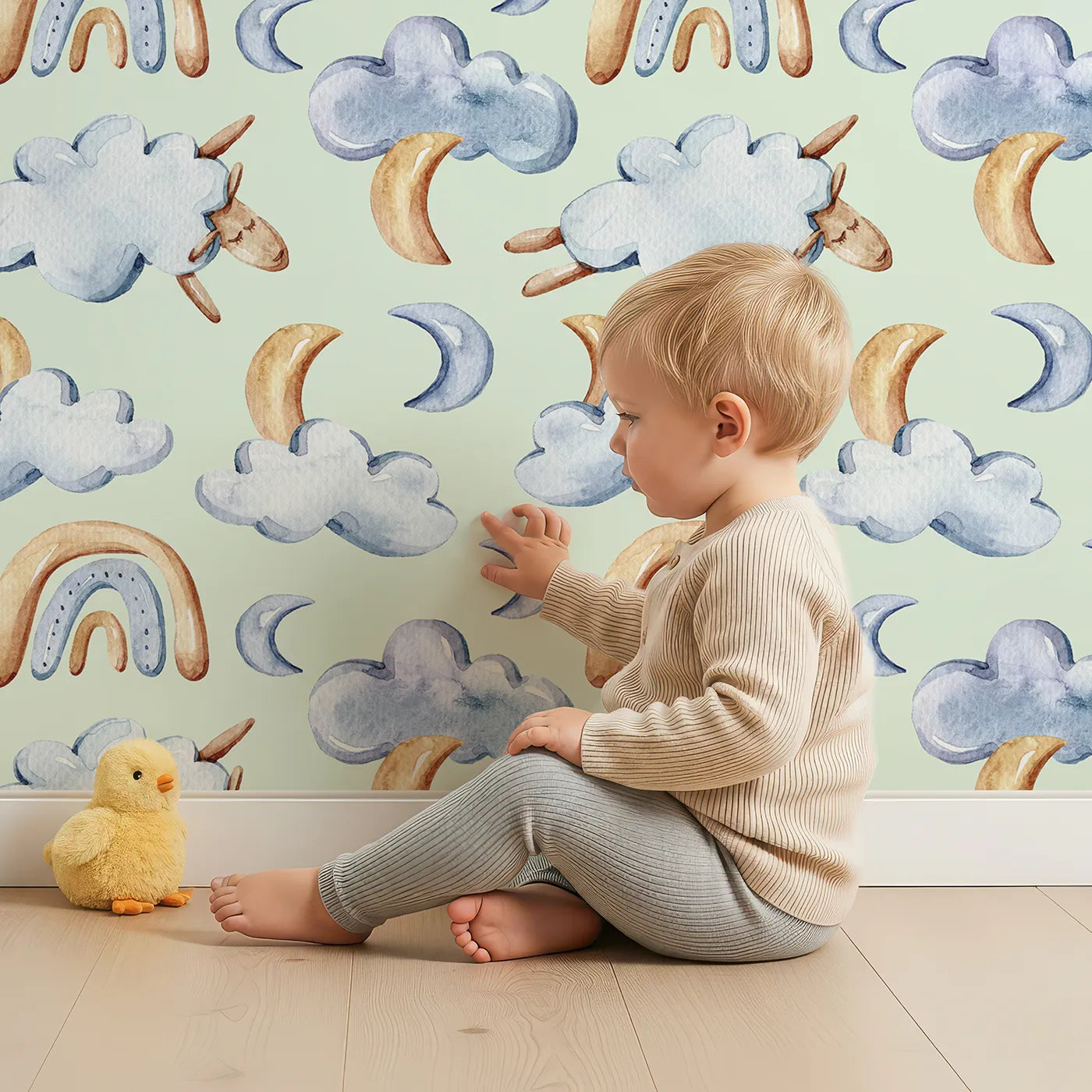 Lovely child standing in front of Whimsy Tots Sleepy Cloud Parade Wallpaper in Mint Green with cloud, moon, sheep, rainbow, star in design.