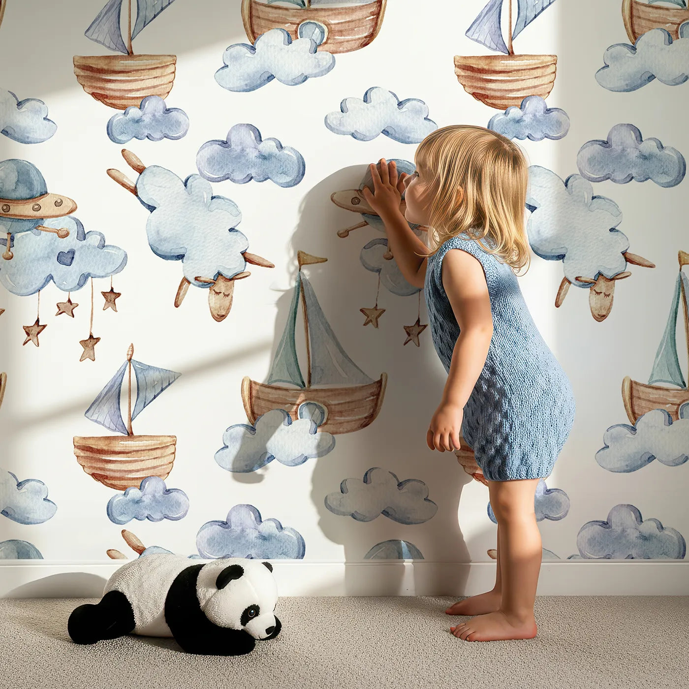 Lovely child standing in front of Whimsy Tots Counting Clouds and Sailing Dreams Wallpaper in White with sheep, boat, cloud, star, mobile in design.