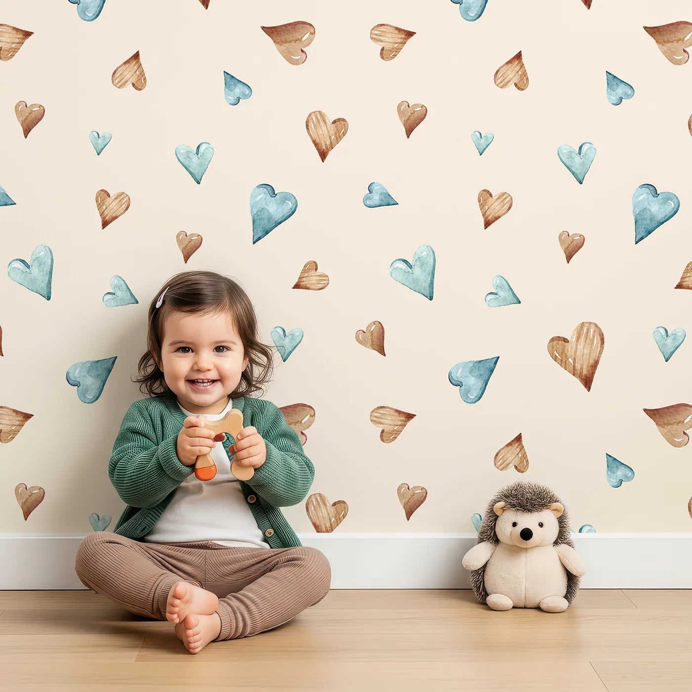 Lovely child standing in front of Whimsy Tots Heartful Whimsy Wallpaper in Sand with heart in design.