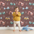 Lovely child standing in front of Whimsy Tots Mighty Machines Construction Wallpaper with truck, crane, excavator, bulldozer, vehicle in design. Lovely child standing in front of Whimsy Tots Mighty Machines Construction Wallpaper with truck, crane, excavator, bulldozer, vehicle in design.