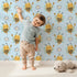 Lovely child standing in front of Whimsy Tots Bee Blossom Parade Wallpaper in Sky with bee, flower, honey in design. Lovely child standing in front of Whimsy Tots Bee Blossom Parade Wallpaper in Sky with bee, flower, honey in design.