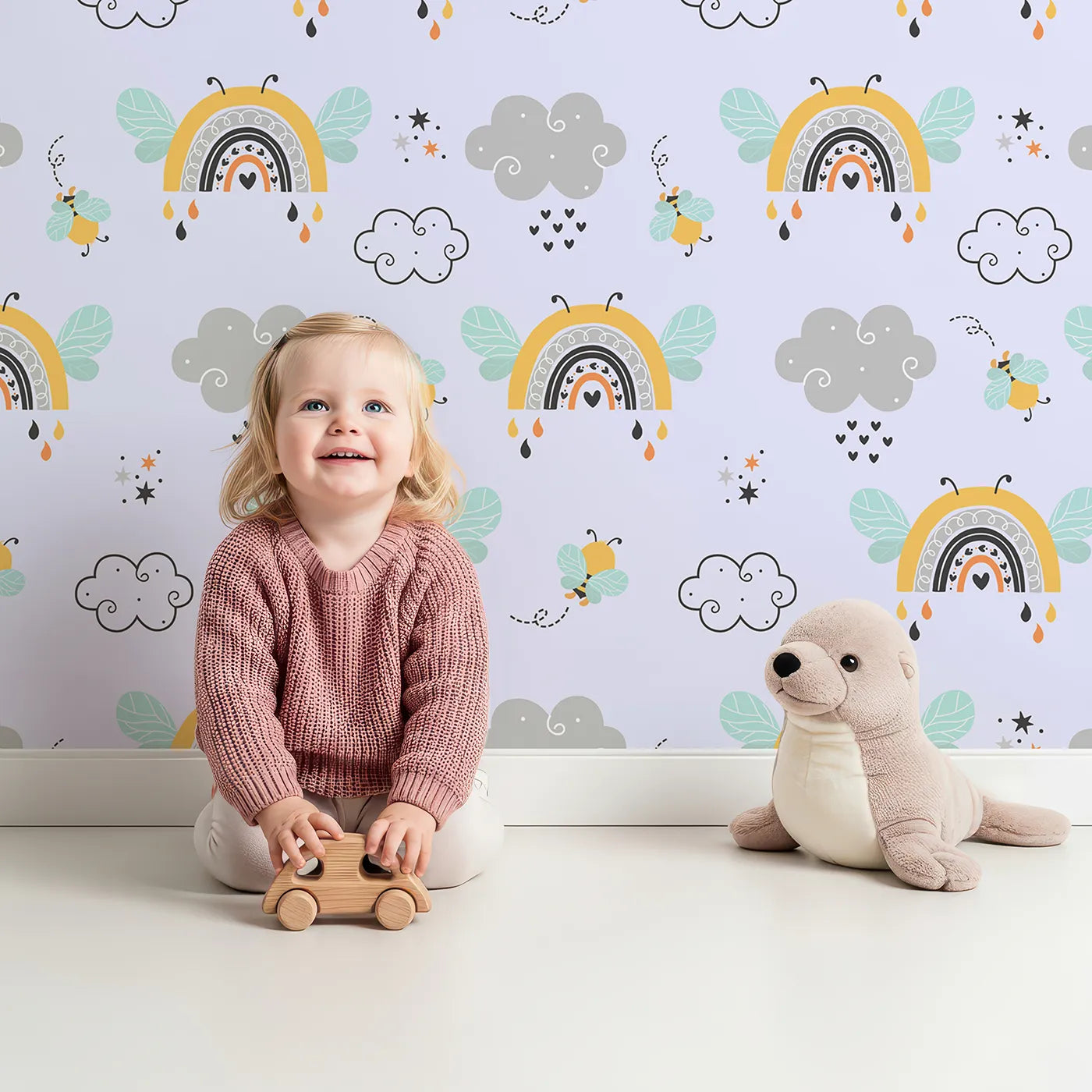Lovely child standing in front of Whimsy Tots Bee Rainbow Dreams Wallpaper in Lavender with bee, rainbow, star, cloud in design.