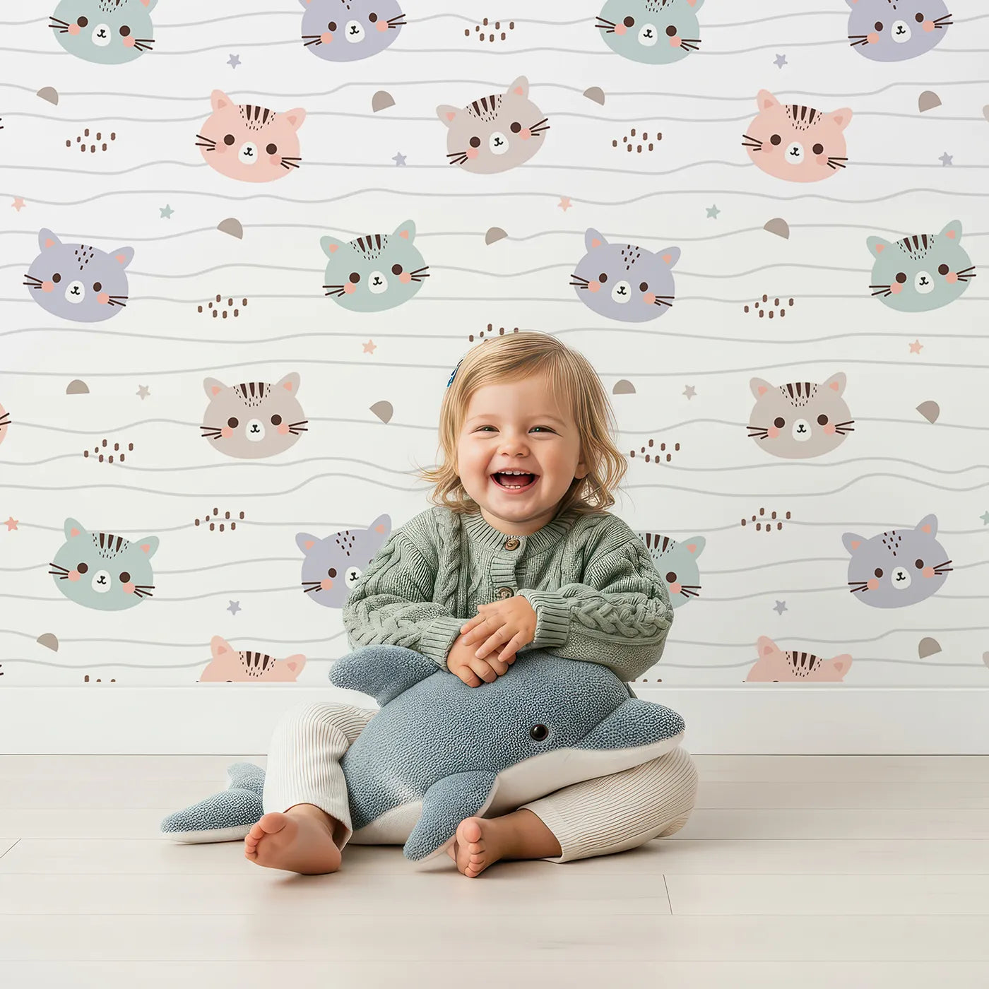 Lovely child standing in front of Whimsy Tots Whisker Wiggle Cats Wallpaper in White with cat, star, stripe in design.