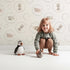 Lovely child standing in front of Whimsy Tots Safari Nap Bubbles Wallpaper in Cream with elephant, zebra, lion, giraffe, hippo, bubble, circle in design. Lovely child standing in front of Whimsy Tots Safari Nap Bubbles Wallpaper in Cream with elephant, zebra, lion, giraffe, hippo, bubble, circle in design.