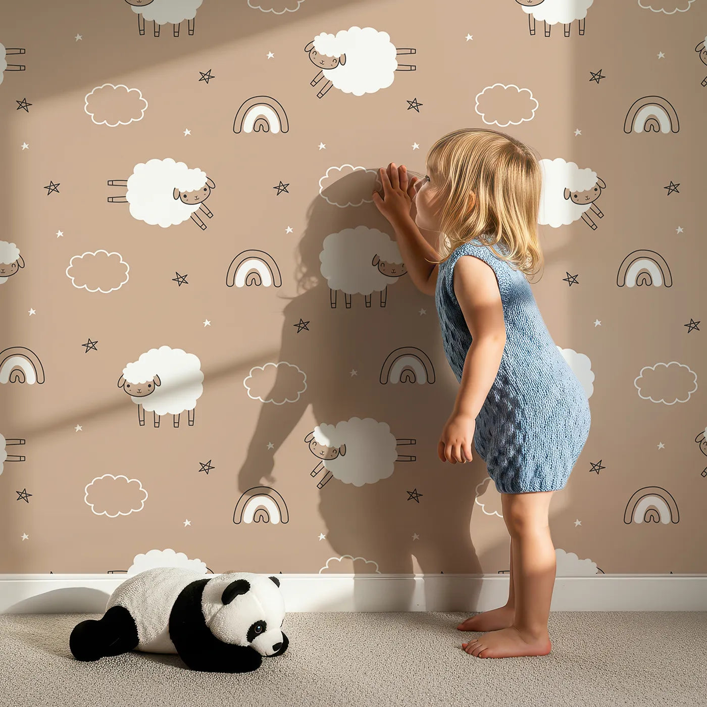 Lovely child standing in front of Whimsy Tots Sleepy Meadow Parade Wallpaper in Mocha with sheep, rainbow, cloud, star in design.