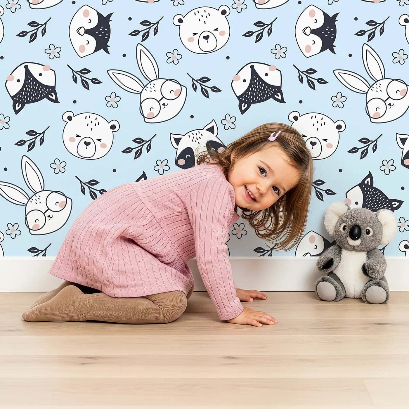 Lovely child standing in front of Whimsy Tots Woodland Scribble Friends Wallpaper in Blue with bear, bunny, fox, raccoon, flower, leaf in design.