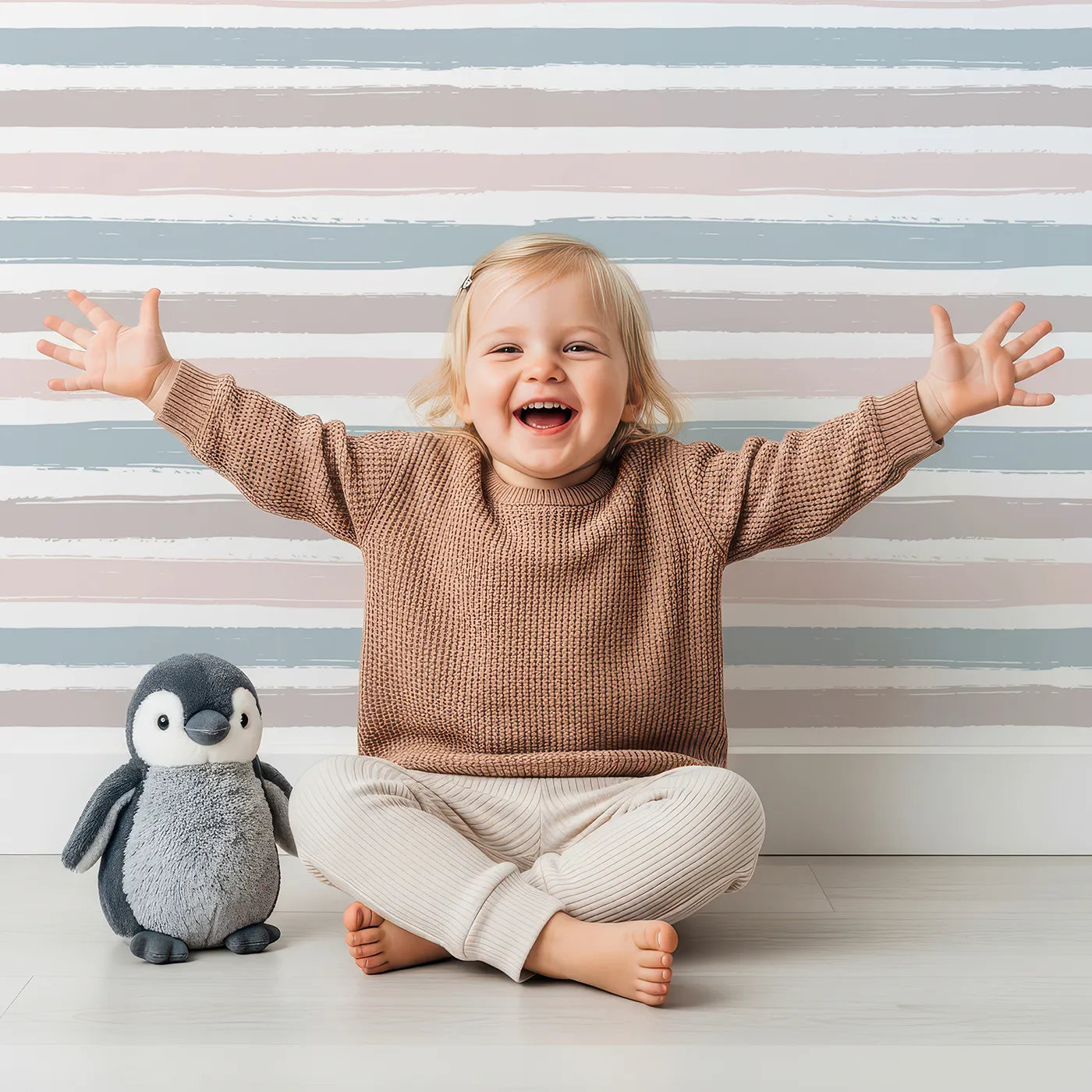 Lovely child standing in front of Whimsy Tots Boho Striped Sky Wallpaper with stripe, brushstroke in design.