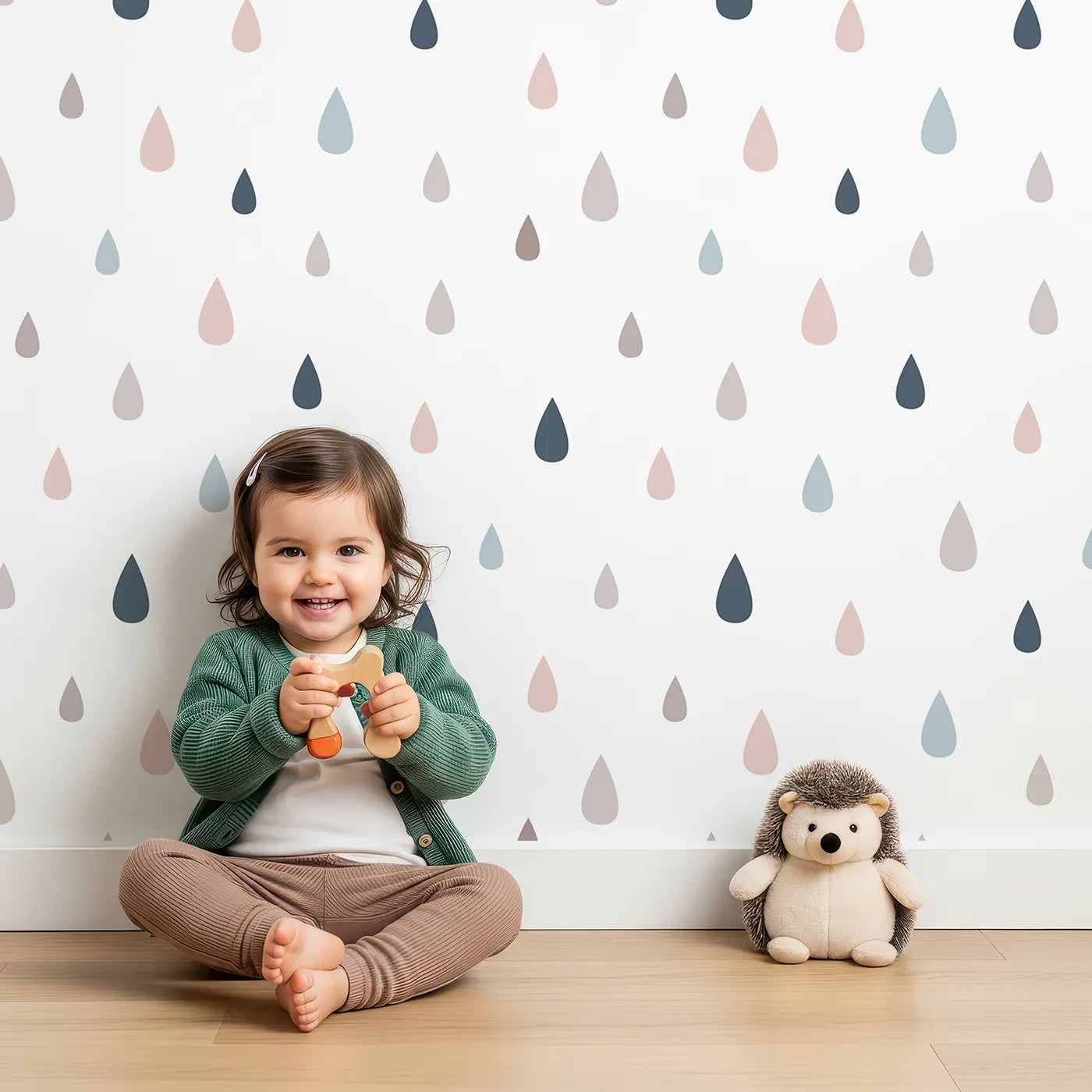 Lovely child standing in front of Whimsy Tots Raindrop Rhythm Wallpaper in Soft Mix with raindrop, shape in design.