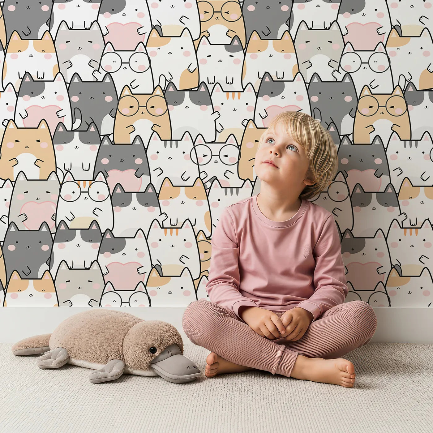 Lovely child standing in front of Whimsy Tots Cuddle Cats Parade Wallpaper in Cream with cat, paw, cheek, heart in design.