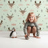 Lovely child standing in front of Whimsy Tots Woodland Deer Wallpaper in Mint Green with deer, cloud, tree, snowflake in design. Lovely child standing in front of Whimsy Tots Woodland Deer Wallpaper in Mint Green with deer, cloud, tree, snowflake in design.
