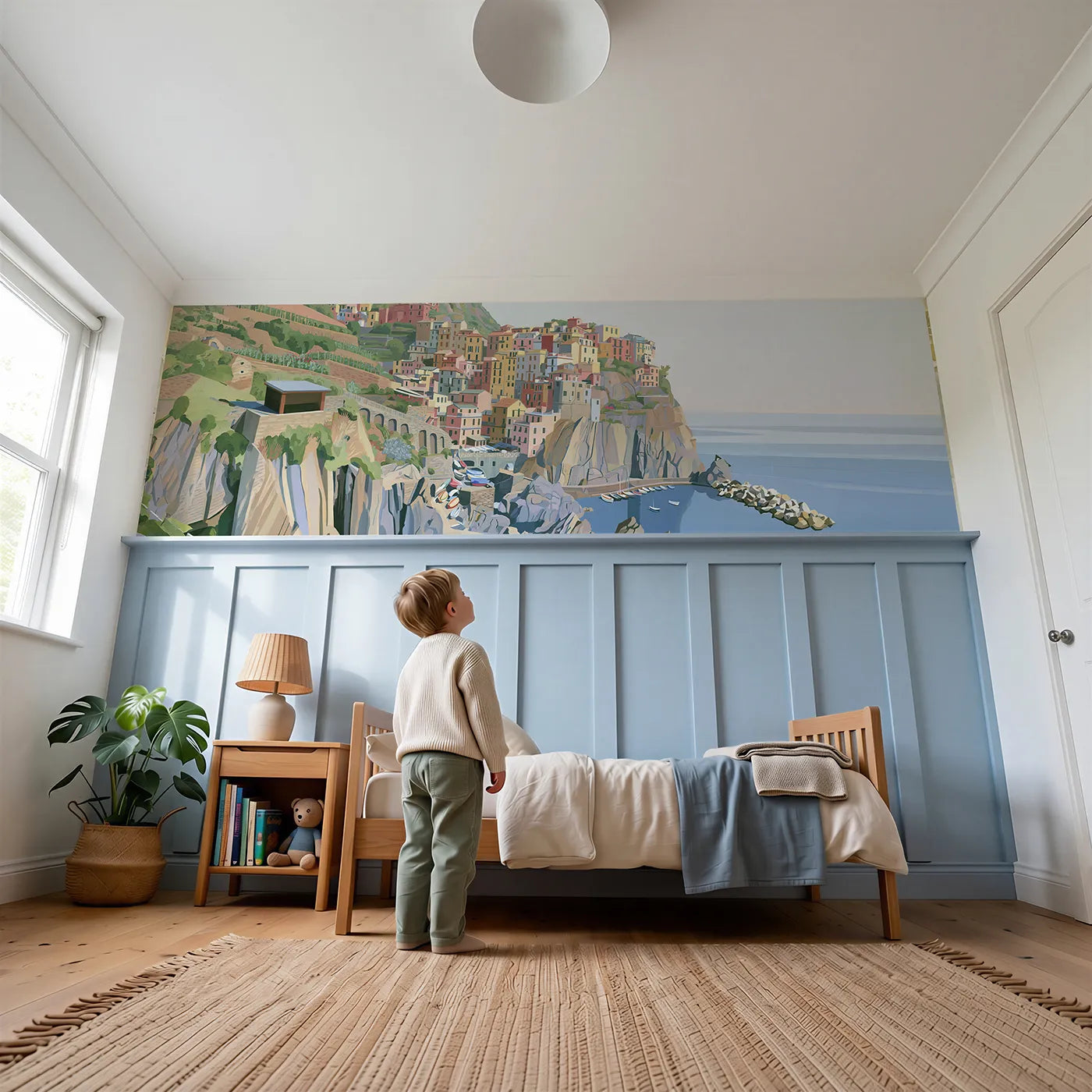 Child reading near Pastel Village On Cliff Wainscoting Wallpaper by Whimsy Tots
