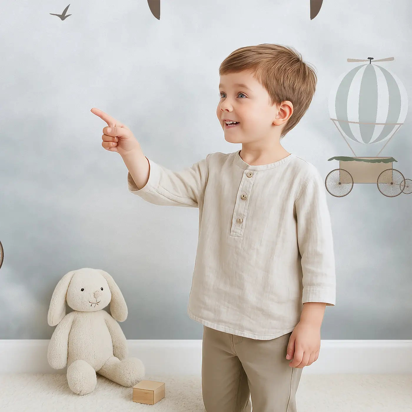 Child in front of Whimsy Tots Vintage Air Adventures Wall Mural with airplane, balloon, cloud, propeller, bird in design.