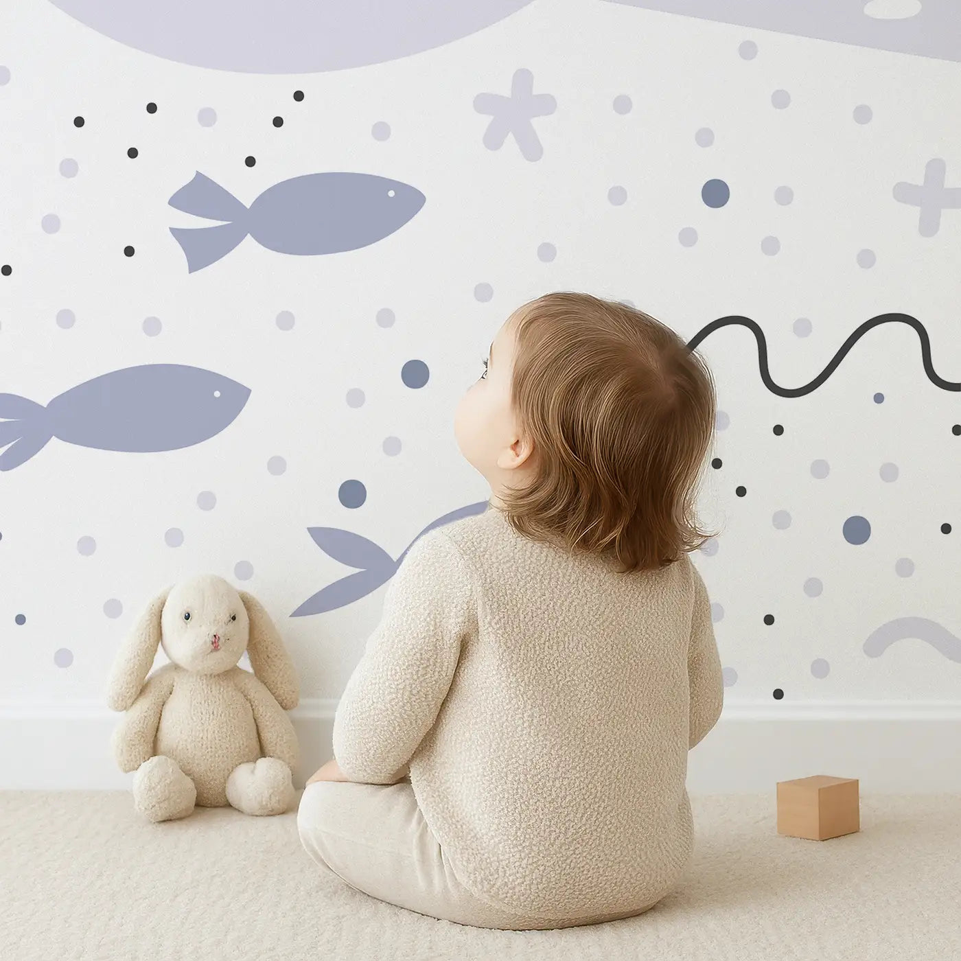 Child in front of Whimsy Tots Ocean Dreamscape Wall Mural with whale, coral, seaweed, rainbow, star in design.