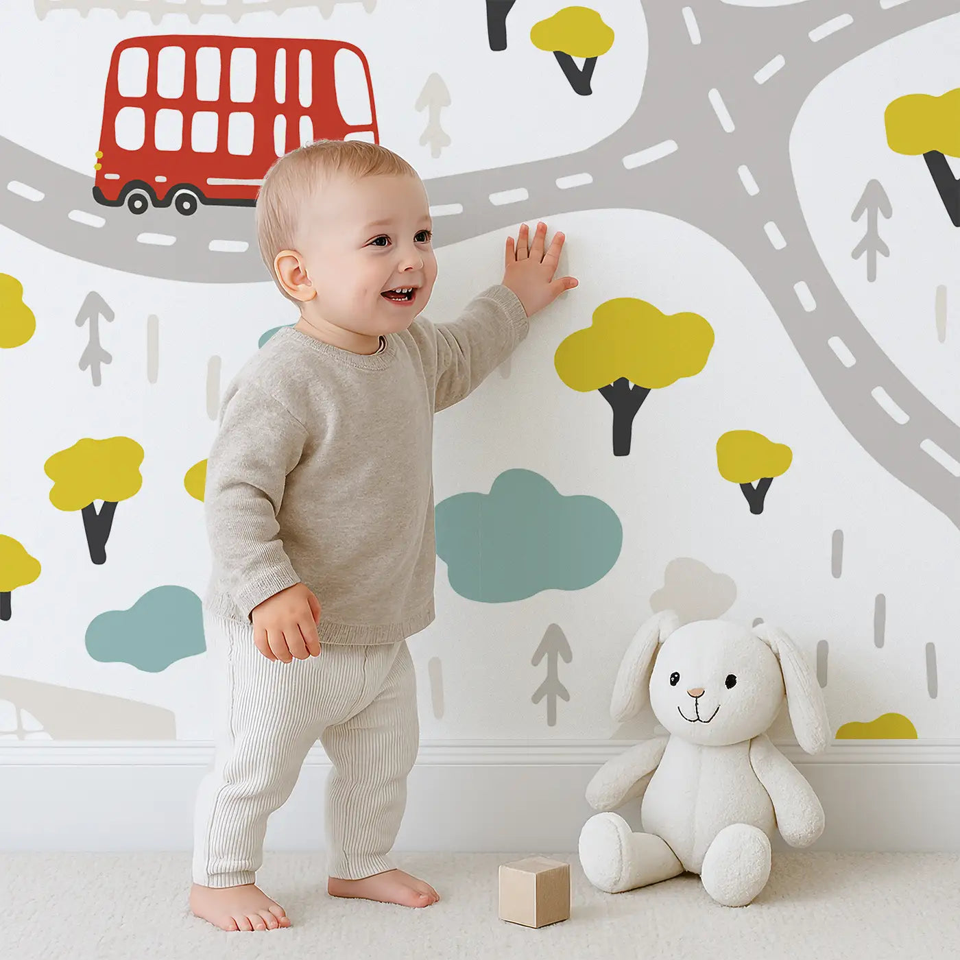 Child in front of Whimsy Tots Busy Town Wall Mural with car, bus, ambulance, truck, city in design.