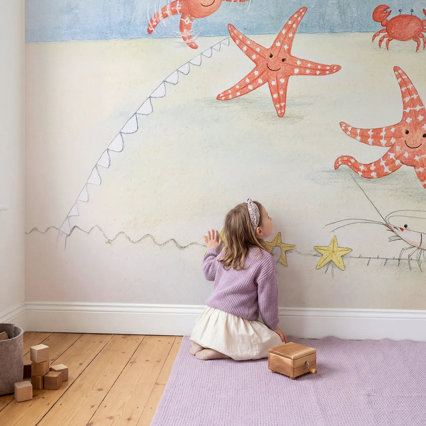 Child in nursery with The Starfish Cartwheel Contest Wallpaper Mural by Whimsy Tots