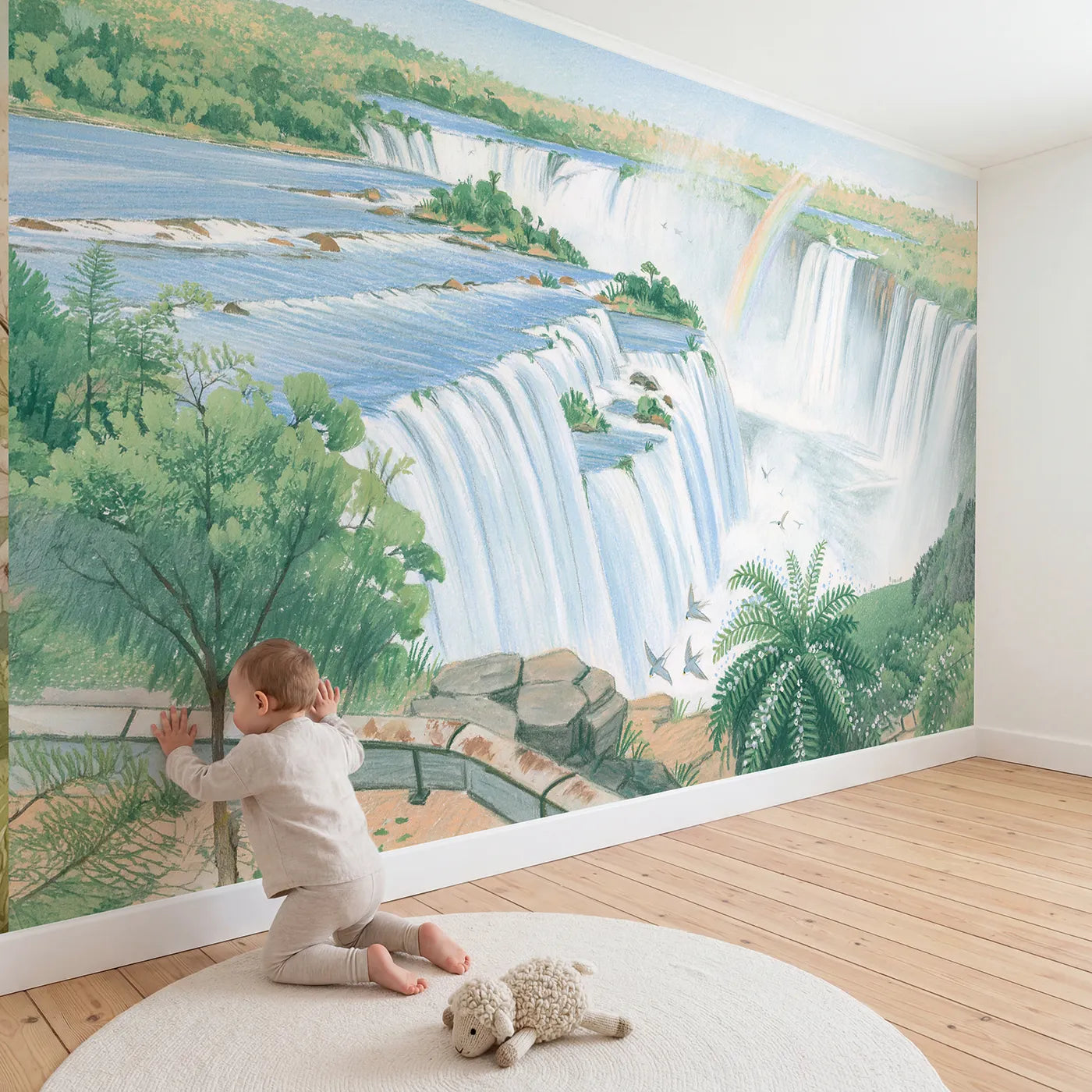 Child in nursery with Iguazu Falls Rainbow Wallpaper Mural by Whimsy Tots