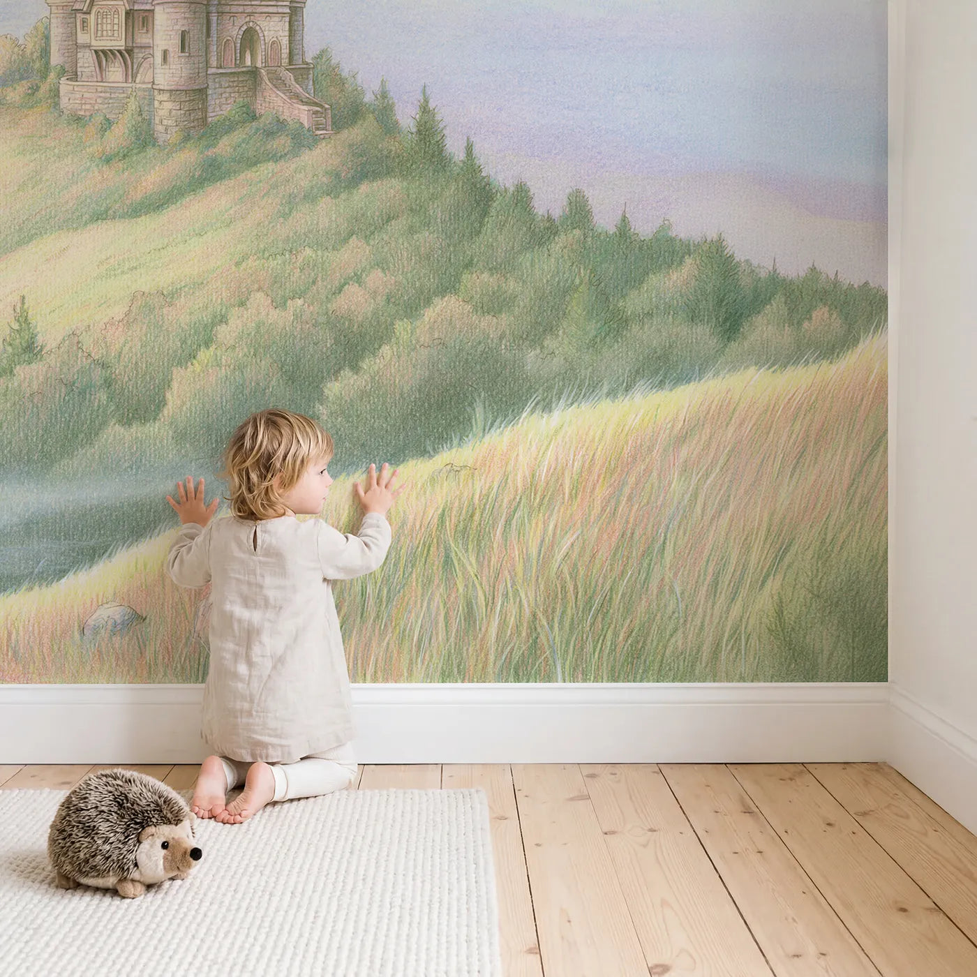 Child in nursery with Fairytale Castle Hill Wallpaper Mural by Whimsy Tots