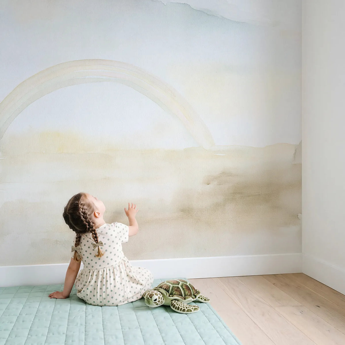 Child in nursery with Dreamy Cloud Rainbow Wallpaper Mural by Whimsy Tots