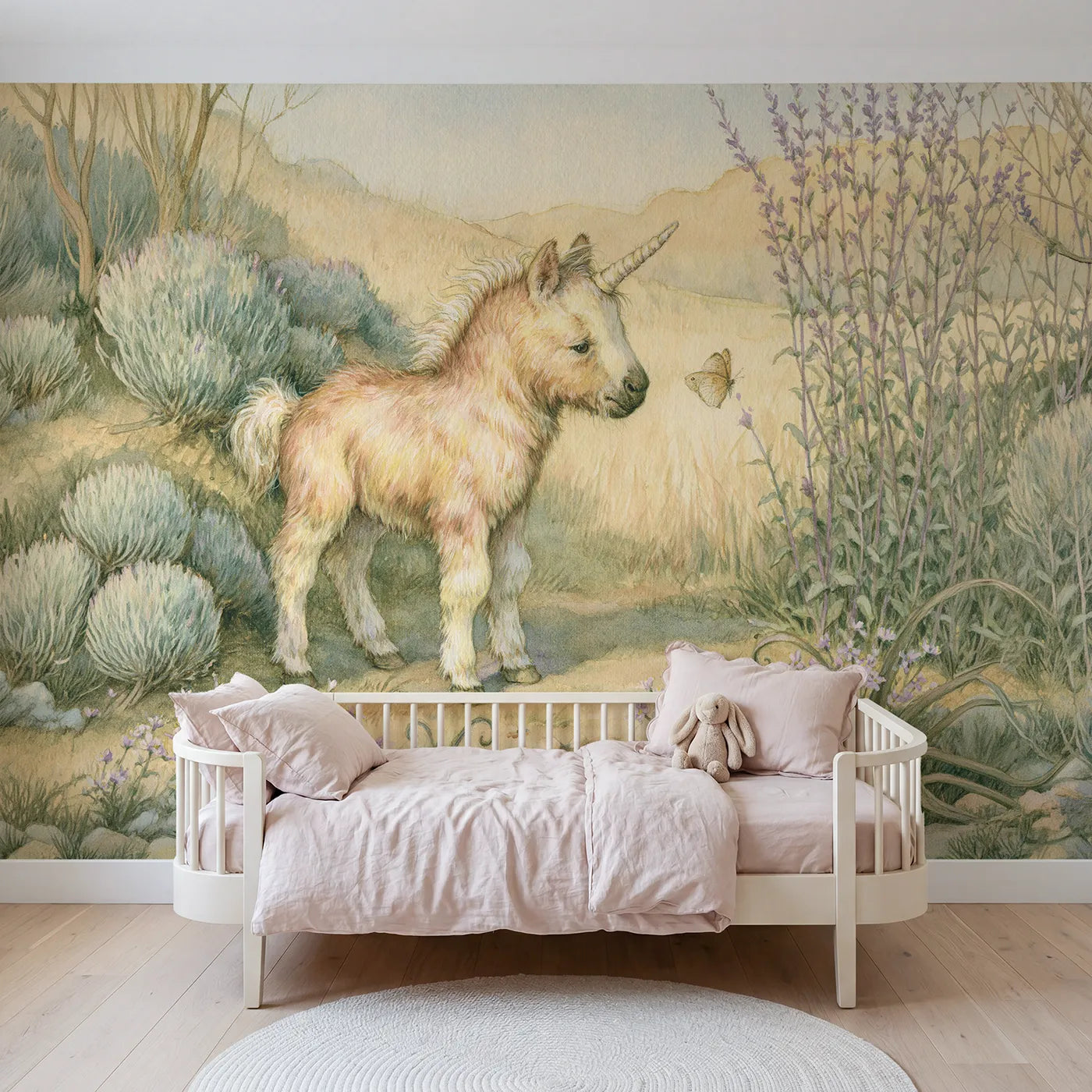 Storybook wall mural of a unicorn nuzzling a butterfly on soft blush by Whimsy Tots