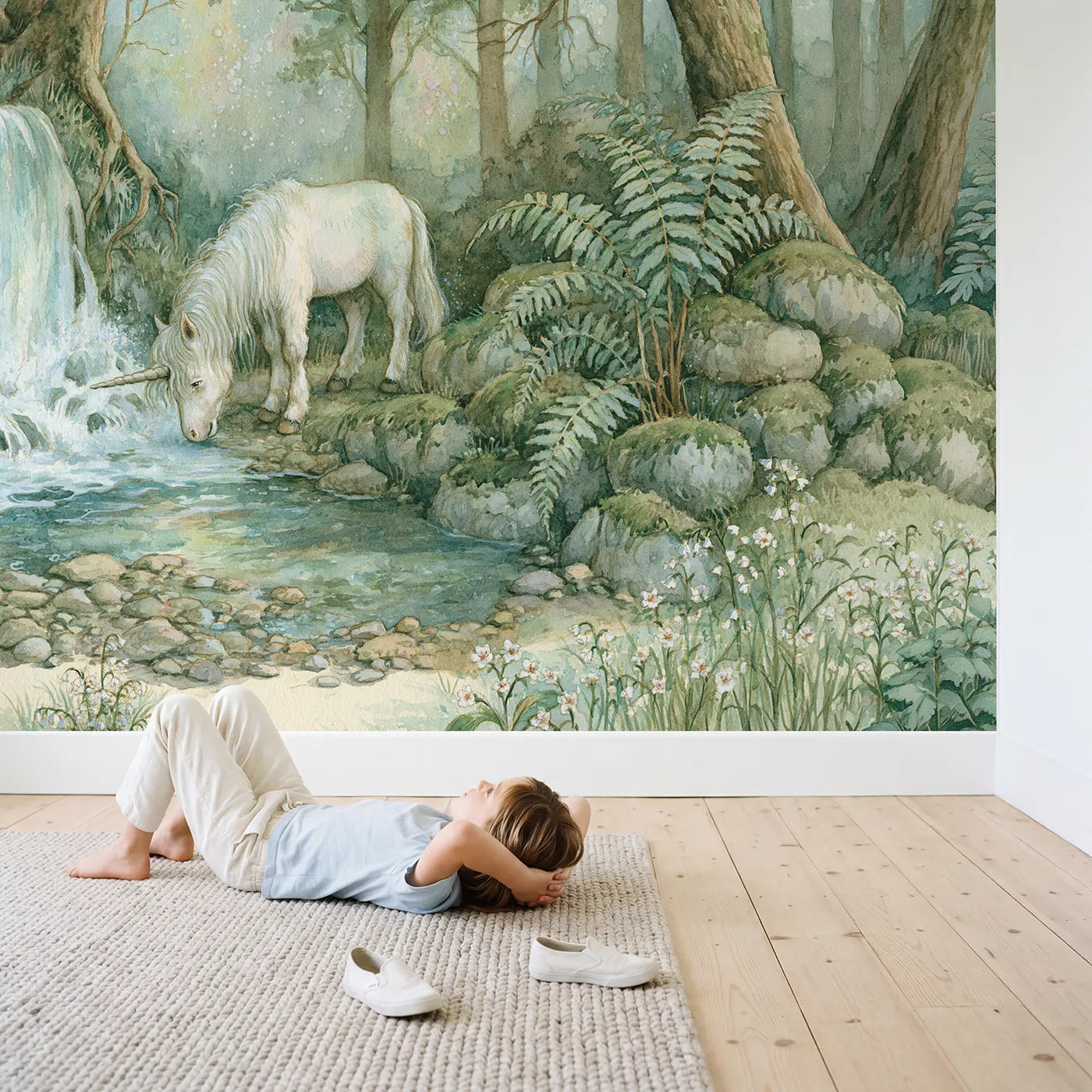 Child in nursery with Unicorn Waterfall Glade Wallpaper Mural by Whimsy Tots
