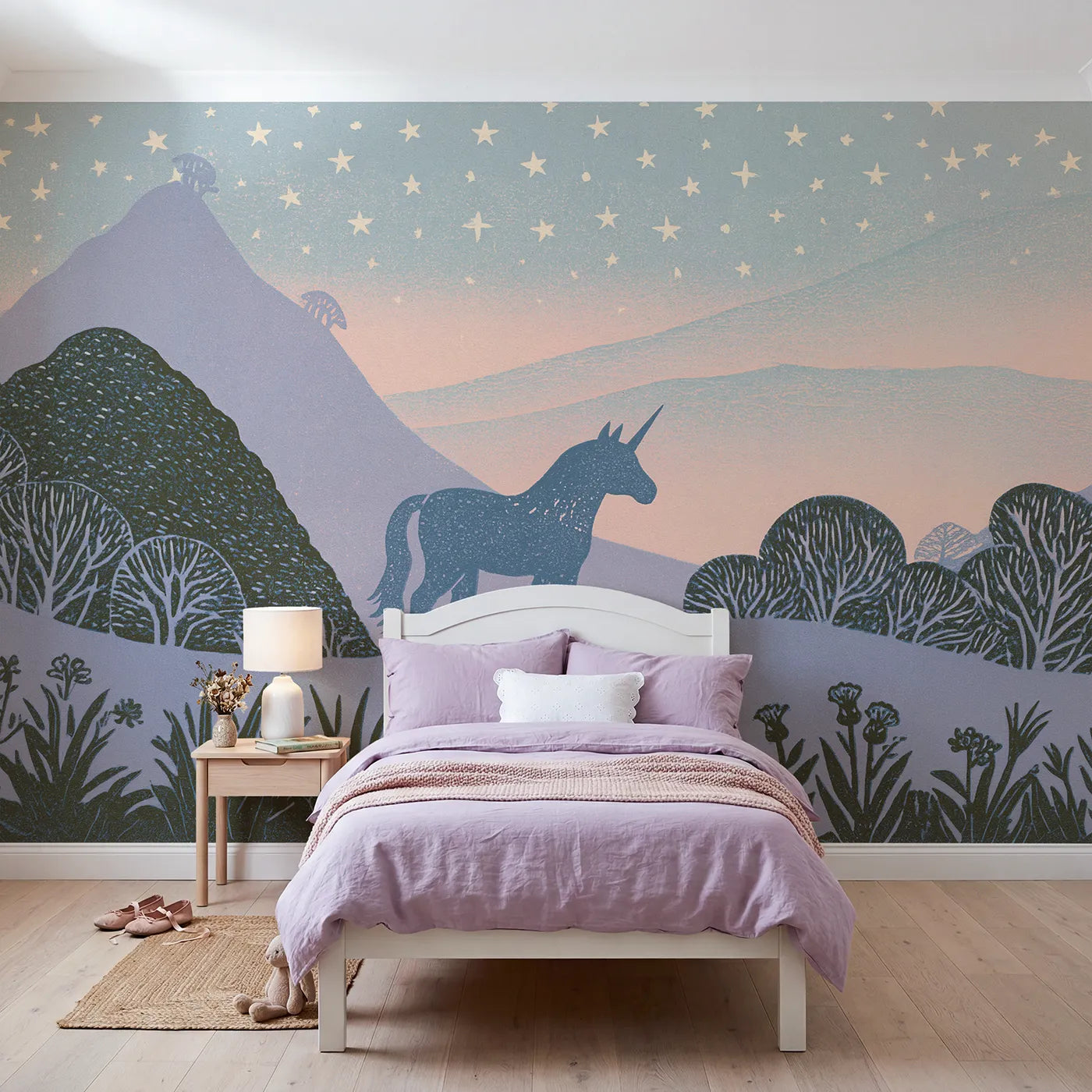 Linocut wall mural of a unicorn among stars in lilac and blush by Whimsy Tots