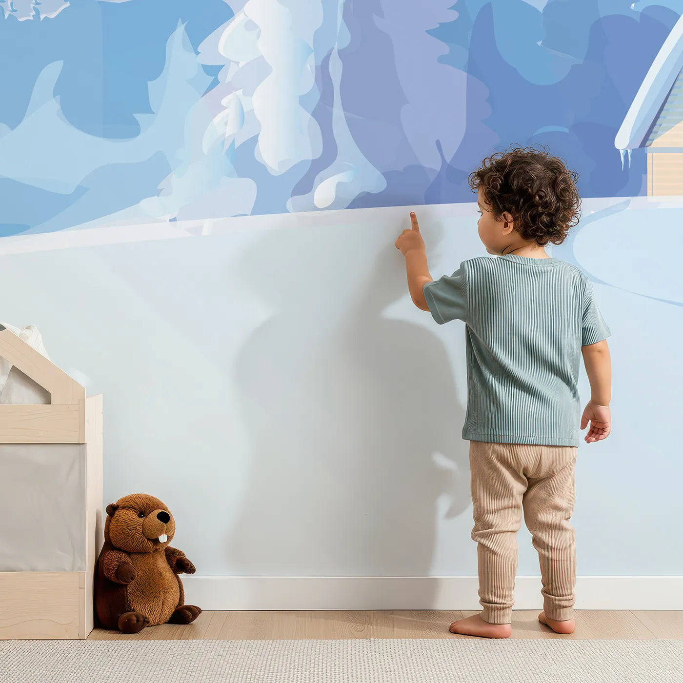 Child in front of Whimsy Tots Cozy Winter Cabin Wall Mural with cabin, mountain, snow, winter, tree, forest, landscape in design.