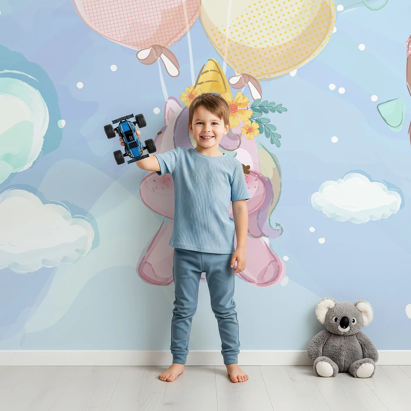 Child in front of Whimsy Tots Unicorn Sky Party Wall Mural with unicorn, balloon, cloud, rainbow, airplane, cute, pastel, magic in design.