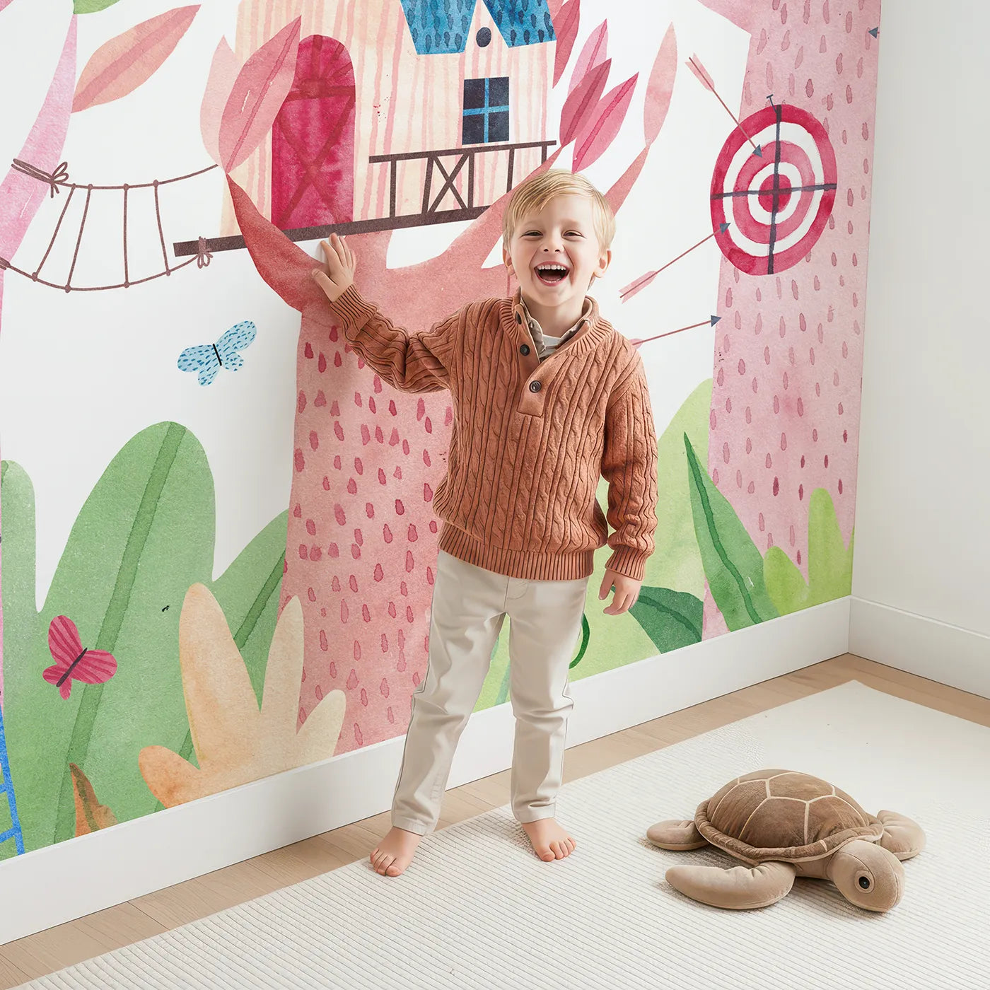 Child in front of Whimsy Tots Watercolor Treehouse Village Wall Mural with treehouse, watercolor, tree, house, colorful, village, kite, playful in design.