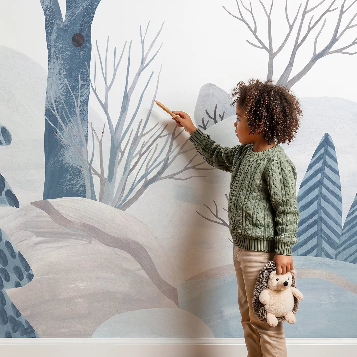 Child in front of Whimsy Tots Winter Woods Watercolor Wall Mural with winter, forest, tree, snow, watercolor, blue, gray, landscape in design.